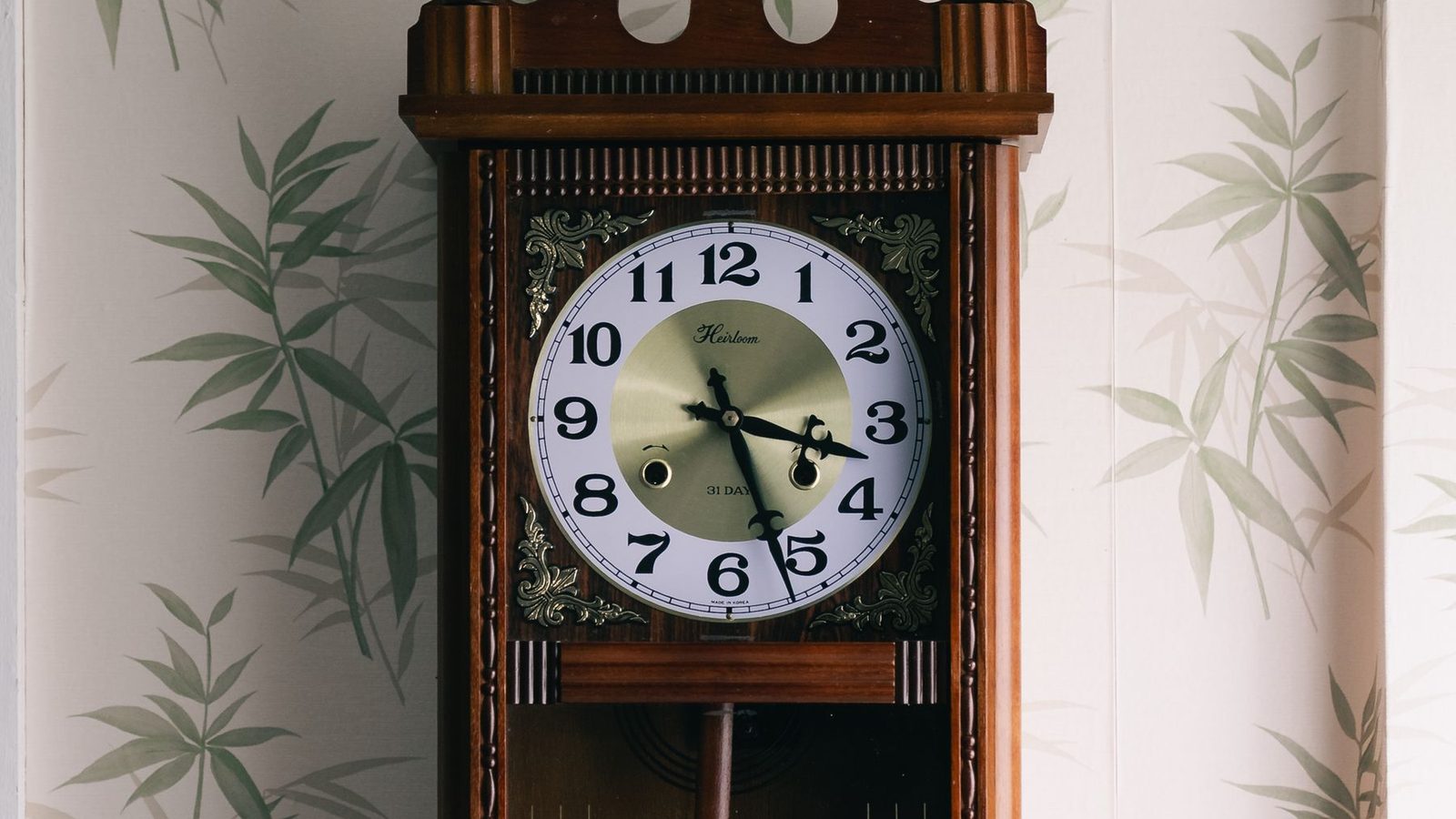 A wall covered in a pale bamboo-leaf grasscloth behind a longcase clock