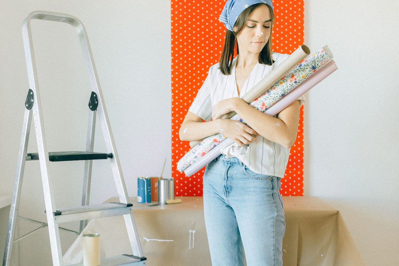 Rolls of peel and stick removable wallpaper held in someone's arms